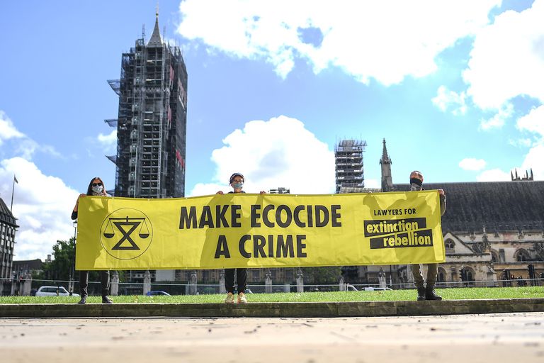 2020年8月28日，在英国伦敦的议会广场，人们举着写有“让生态灭绝成为犯罪”的横幅。